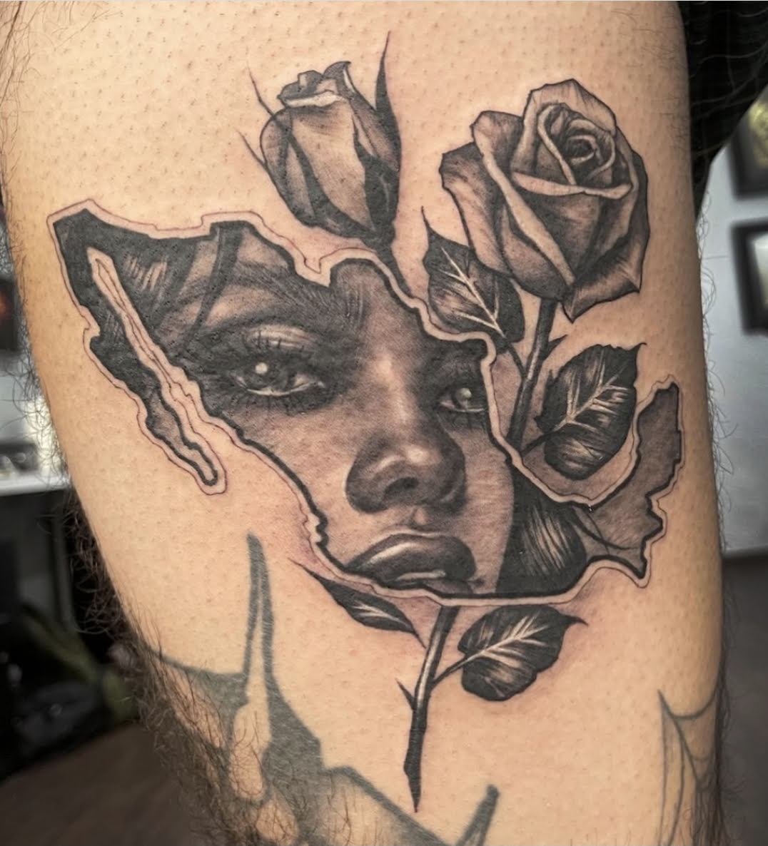 Tatuaje de retrato realista con rosas en blanco y negro, realizado en Tattoo Pappa